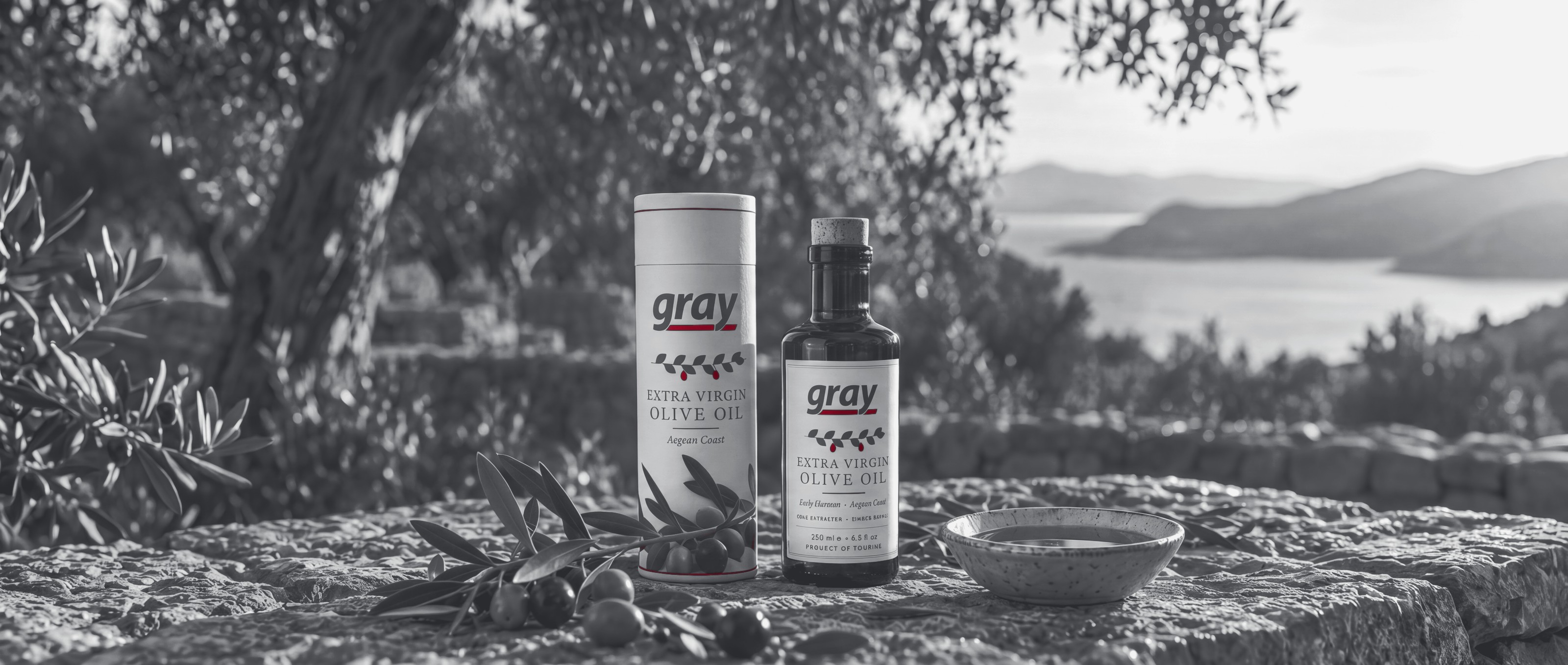 Gray cylinder tube and labelled olive oil bottle in an Aegean olive grove